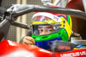 Piloto de Fórmula Vee usando capacete homologado dentro do cockpit do carro, demonstrando equipamentos de segurança obrigatórios no automobilismo.