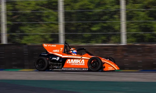 Carro de Fórmula Vee da AMIKA Racing em alta velocidade durante corrida em autódromo.