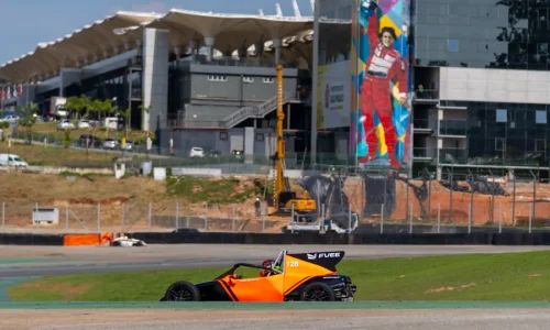 Carro de Fórmula Vee contornando uma curva no Autódromo de Interlagos, com a torre do circuito ao fundo.