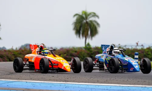 Dois carros da Fórmula Vee disputando posição em pista de automobilismo durante corrida da categoria no Brasil